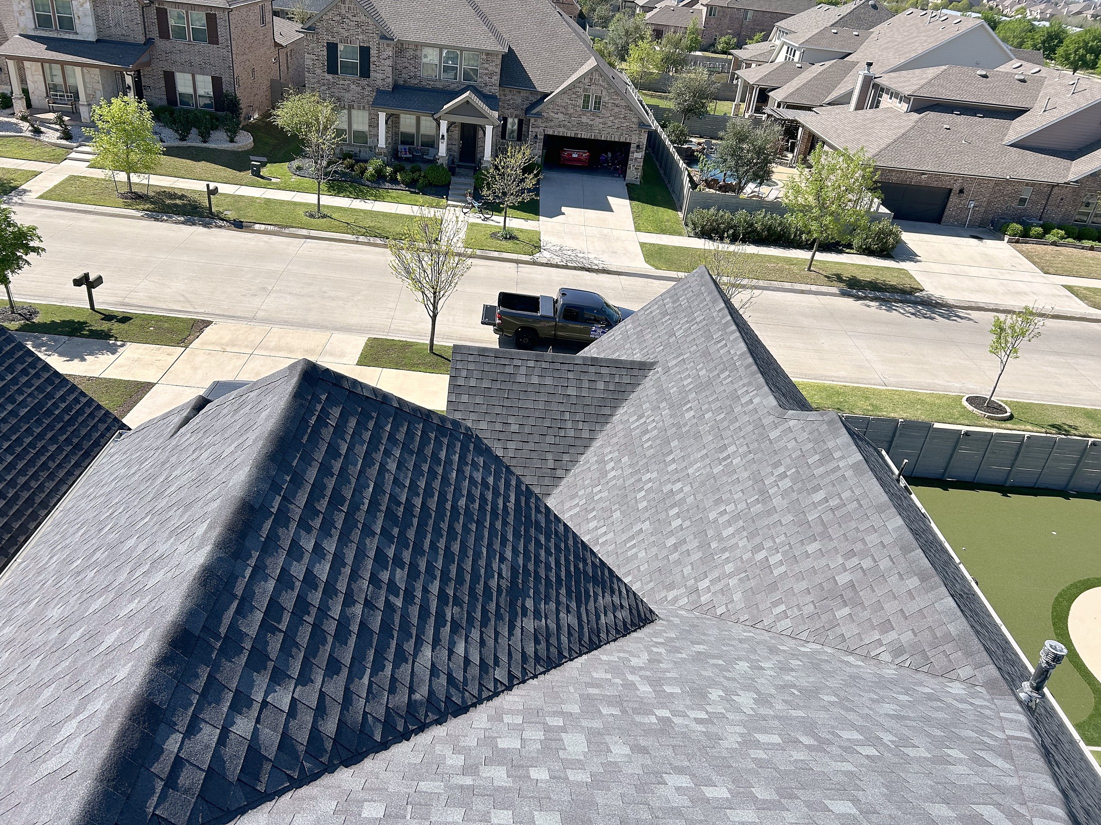 Aerial view of a freshly shingled gray roof in a new North Texas neighborhood